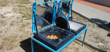 Fornos solares com maçãs e pão